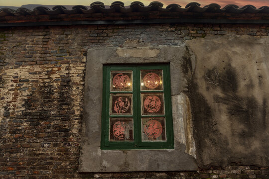 Traditional Chinese House Exterior with Green Window and Red Paper Cutouts