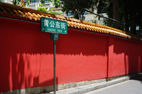 Green street sign on red wall in Kunming, China
