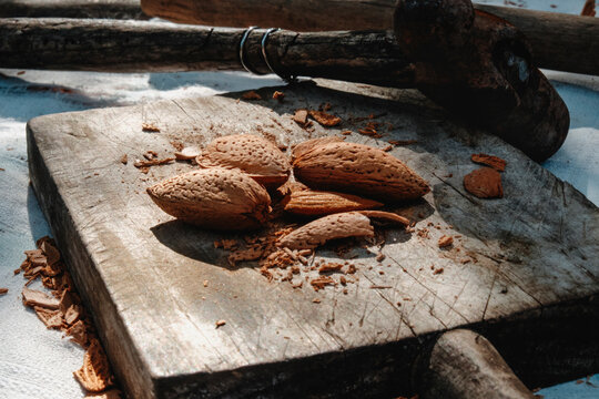 almonds and broken shells beside a rusty hammer