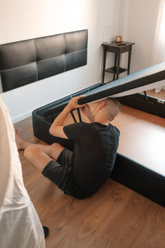 man working beneath a raised storage bed