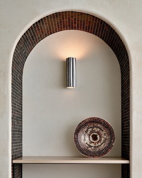 Minimalist arched niche with brown mosaic tile and chrome wall sconce for interior design background and poster