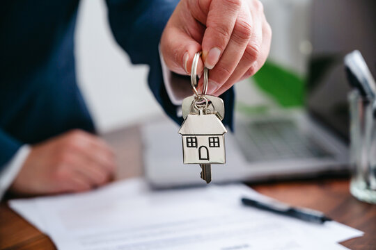 Real estate agent presenting house keys to new home owner