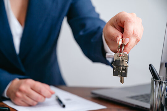 Real estate agent handing over house keys after property purchase