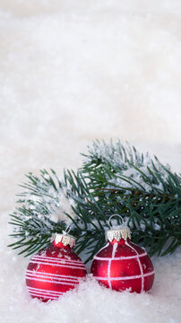 red christmas bauble decoration with fir tree twig isolated in snow background with copy space, social media template for december holiday season greeting card