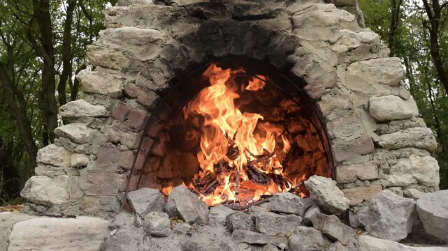 Fire burning in old outdoor stone oven with crackling sound