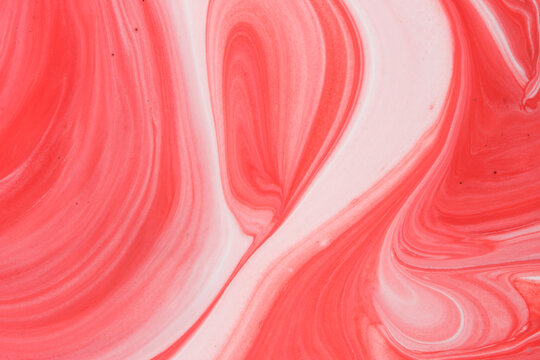Smooth abstract fluid background swirling pink, red, and white pastel paint marble textures.