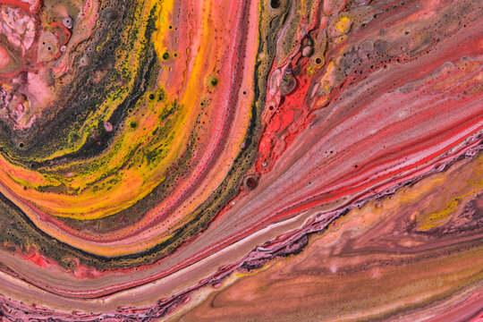 Vibrant liquid art marble background with dynamic yellow, orange, red, and black paint swirls.