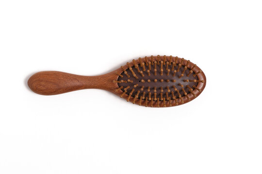 Top flat lay view natural eco friendly wooden massage hairbrush isolated on white background.