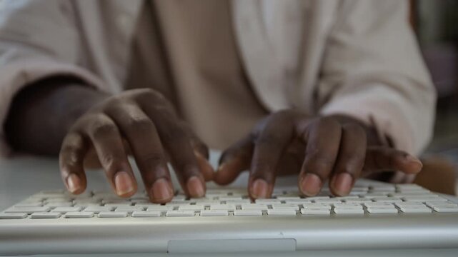 African American anonymous man typing on computer keyboard in extreme close up. Footage suitable for software development, remote work, copywriting or digital communication projects