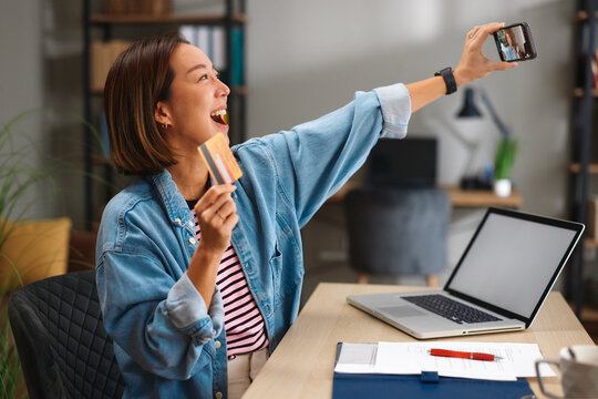 Woman shopping online with credit card and smartphone at home