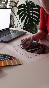 Designer examines wood veneer samples to choose interior design materials