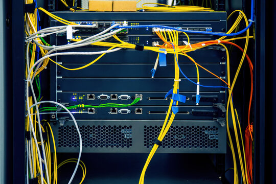 Fiber optic network switches and cables inside telecom rack for broadband internet infrastructure, high speed data transmission and enterprise connectivity.
