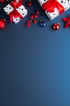 Merry Christmas and Happy Holidays greeting card, frame, banner. New Year. Red Christmas ornaments and gifts, presents on blue background top view. Xmas holiday festive theme. Christmas decoration.