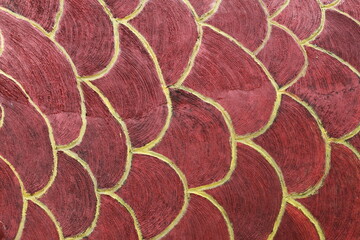 Rough textured wall with fish scale pattern creating a unique decorative surface design. © Fauzi Stock