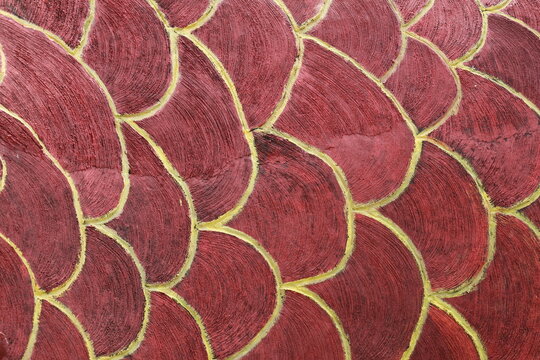 Rough textured wall with fish scale pattern creating a unique decorative surface design.