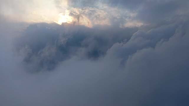 Sky pierces through clouds, casting soft, diffused light. Clouds roll, thick and gray