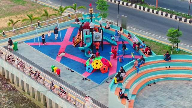 Aerial view of Teras Samarinda 2 playground with colorful equipment and children playing on rubber flooring in Samarinda, East Kalimantan, Indonesia.