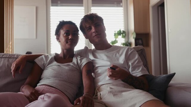 Young couple watching TV together in cozy living room
