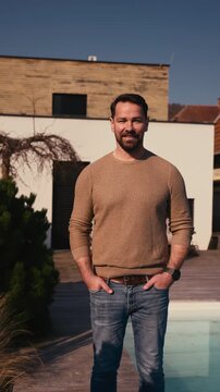 Man enjoying warm spring sunlight on face while standing outside.