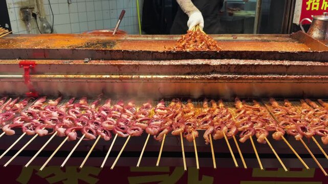 Street vendor grilling meat skewers on night market food stall