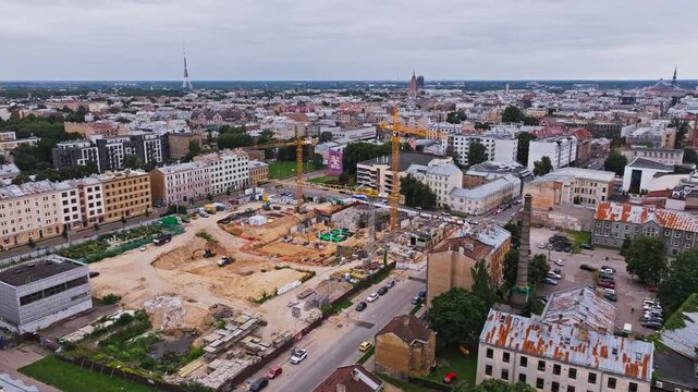Wide aerial reveals cranes and active construction across central Riga, Latvia