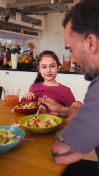Family enjoying lunch together at dining table in modern home.