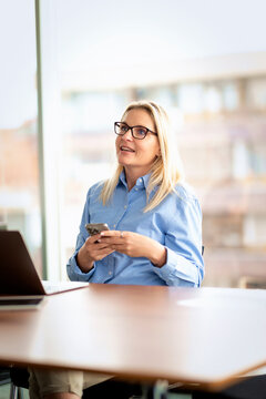 Confident businesswoman working on a laptop in a modern corporate office