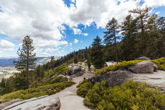 Hikers walking along scenic mountain trail at Glacier Point in Yosemite National Park California