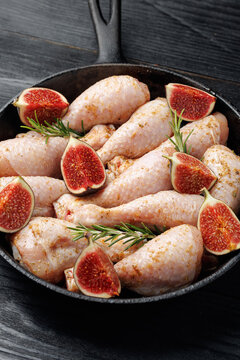 Raw Chicken Drumsticks with Fresh Figs and Rosemary in Cast Iron Skillet