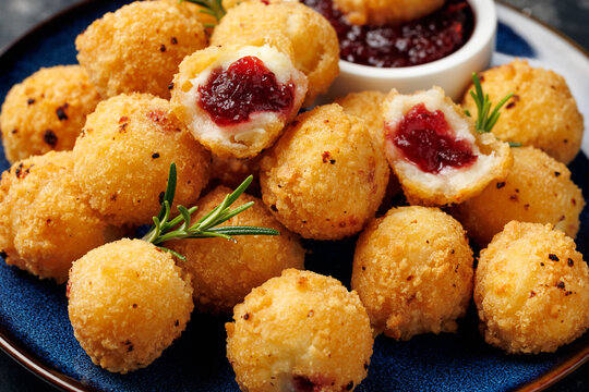 Party appetizers with brie cheese, cranberry sauce and fresh rosemary on crackers, served on plate