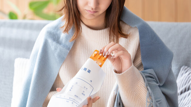 薬を飲む体調不良の女性