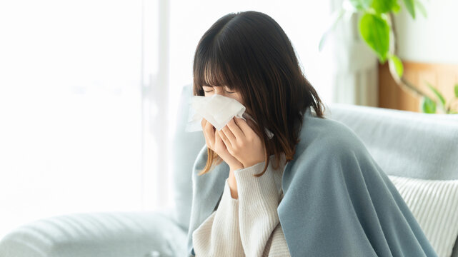 風邪を引いてくしゃみをする女性・花粉症