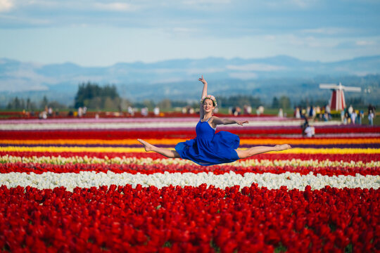 Ballet white dancer leaping over colorful tulip fields