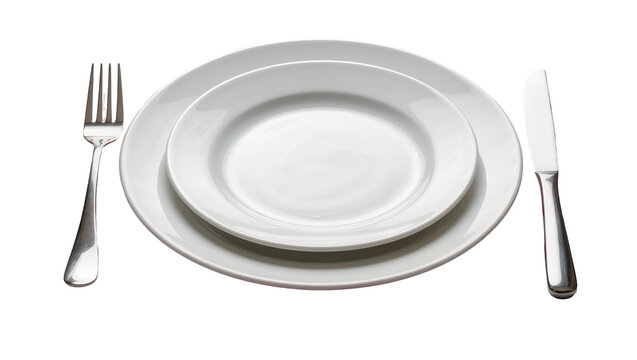 Two white ceramic plates stacked with a silver fork and knife, isolated on transparent background