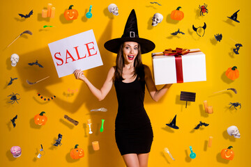 Portrait of her she nice attractive pretty slender cheerful cheery lady wizard holding in hands card sale giftbox congrats greetings isolated over bright vivid shine vibrant yellow color background © deagreez
