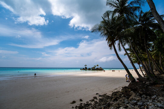 Malay, Western Visayas, Philippines - 01 October 2026: View of Boracay Island with its white sand beach, turquoise water, and palm trees under a blue sky with scattered clouds.