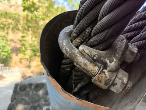 Close up of heavy duty steel wire rope cable clamp on suspension bridge construction