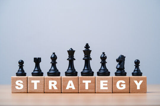 Business strategy and planning concept with black chess pieces on wooden blocks spelling STRATEGY symbolizing for leadership, competitive advantage and corporate success.