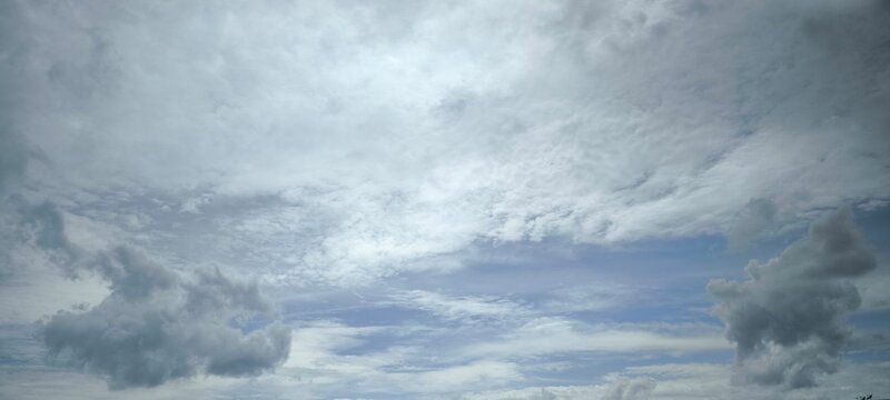 White clouds tinged with light gray floating in the sky.