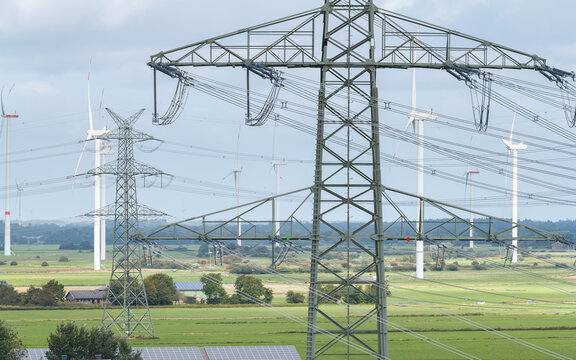 Strommast einer Hochspannungsleitung mit Windpark in Nordfriesland
