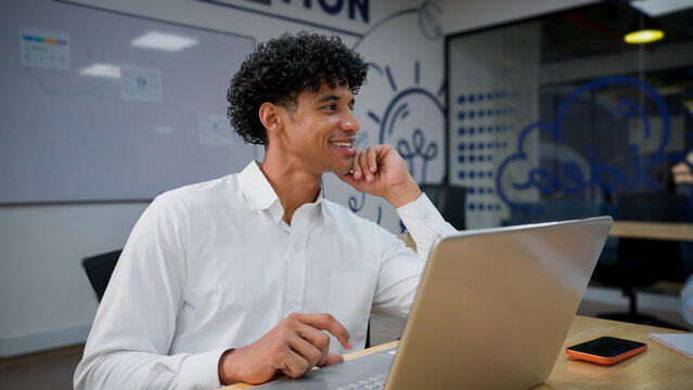 Relaxed Executive Using A Laptop During A Work Break In A Coworking Space