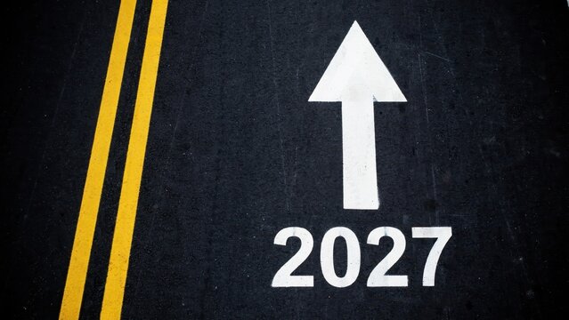 Asphalt road features a large white arrow pointing forward and the number 2027, symbolizing future goals and progress.