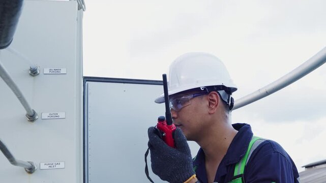 Environmental engineer communicating with team of technicians use radio and taking reports checking continuous emission monitoring systems at industrial plant. Sustainable air pollution reduction. ESG
