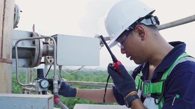 Environmental engineer communicating with team of technicians use radio and taking reports checking continuous emission monitoring systems at industrial plant. Sustainable air pollution reduction. ESG