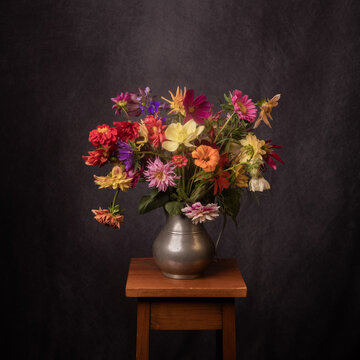 painterly renaissance still life with colorful summer flowers in jug on stool