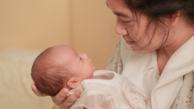 Maternal love, bonding, intimacy and family tenderness. Close up of a mother gazing affectionately at her newborn baby, highlighting their face to face connection in soft natural light.