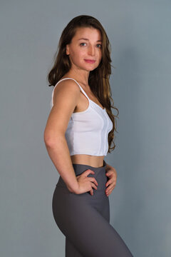 Confident female Pilates instructor in a relaxed professional pose, in a three-quarter pose with long hair