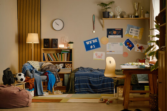 Empty messy teenager bedroom interior with study desk and bed, representing youth lifestyle and domestic everyday life. Ideal for parenting, home organization and education campaigns