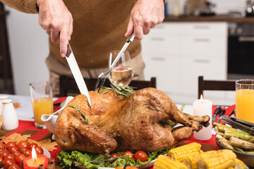 Obraz premium Man carving a golden roasted turkey for Thanksgiving dinner