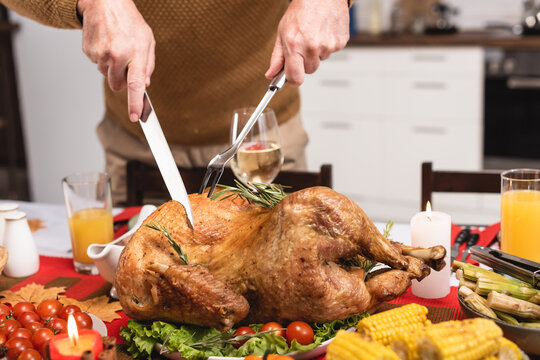 Man carving a golden roasted turkey for Thanksgiving dinner